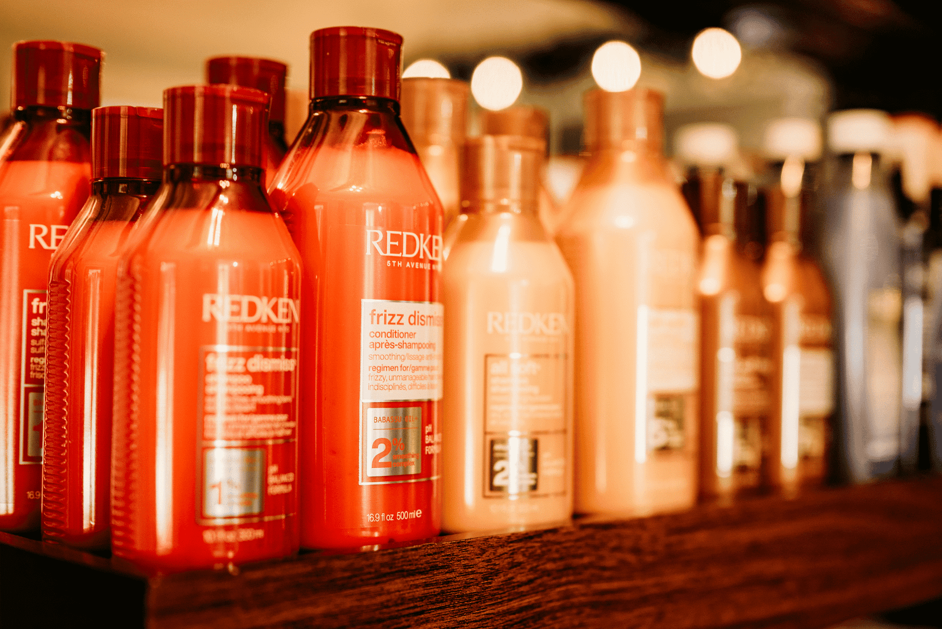 Shelves stocked with various Redken hair care products in a salon.