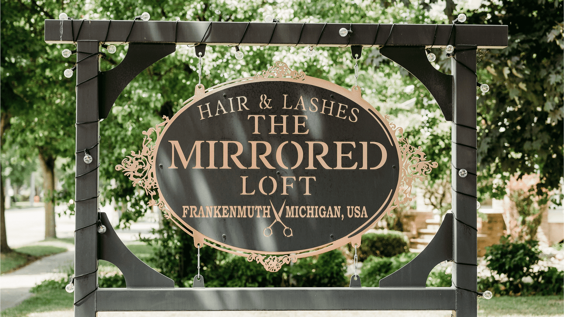Sign for The Mirrored Loft Hair & Lashes salon in Frankenmuth, Michigan, USA.