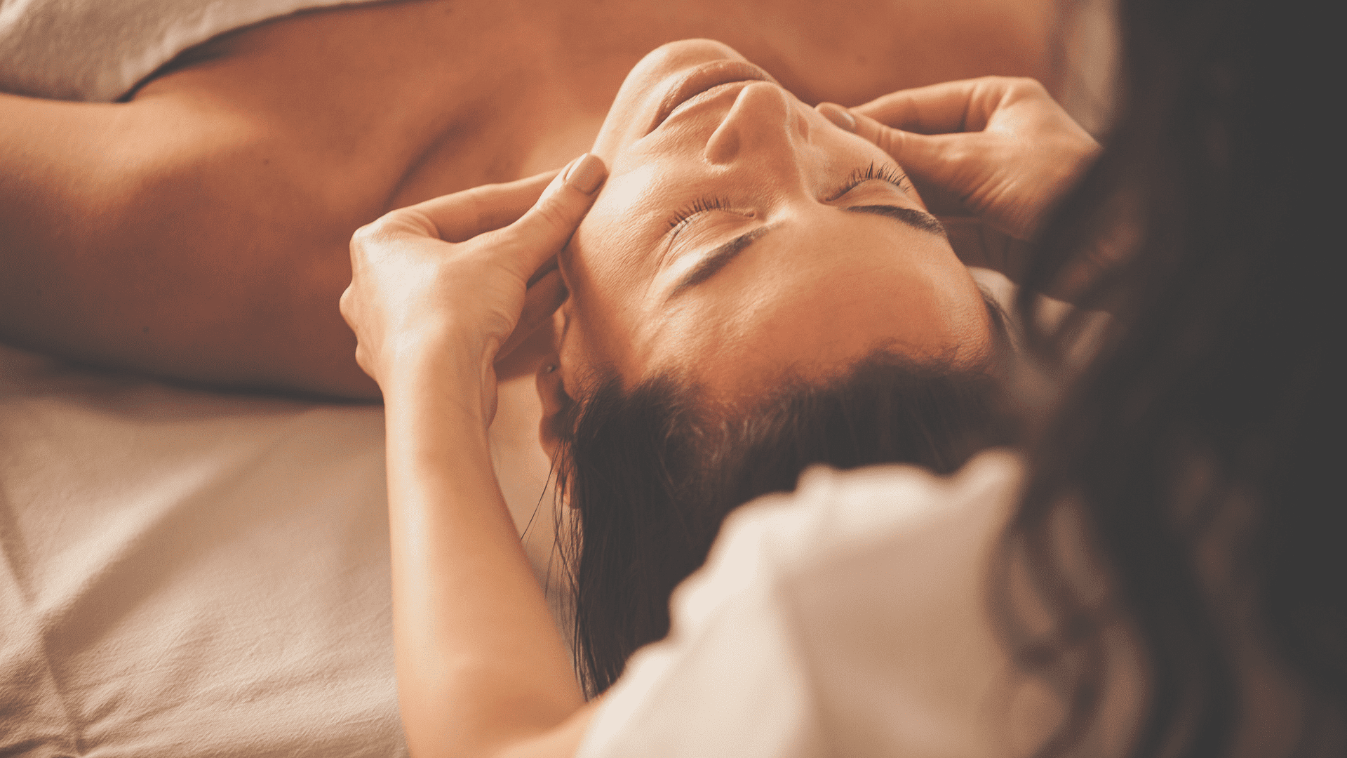 Person receiving a relaxing facial massage in a serene spa setting.